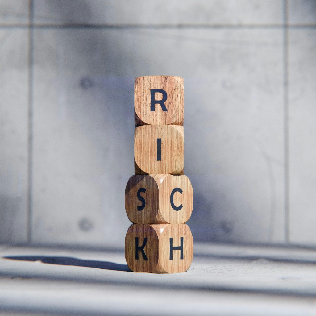 Stacked wooden blocks spelling 'RISK' concept, symbolizing caution and strategy.